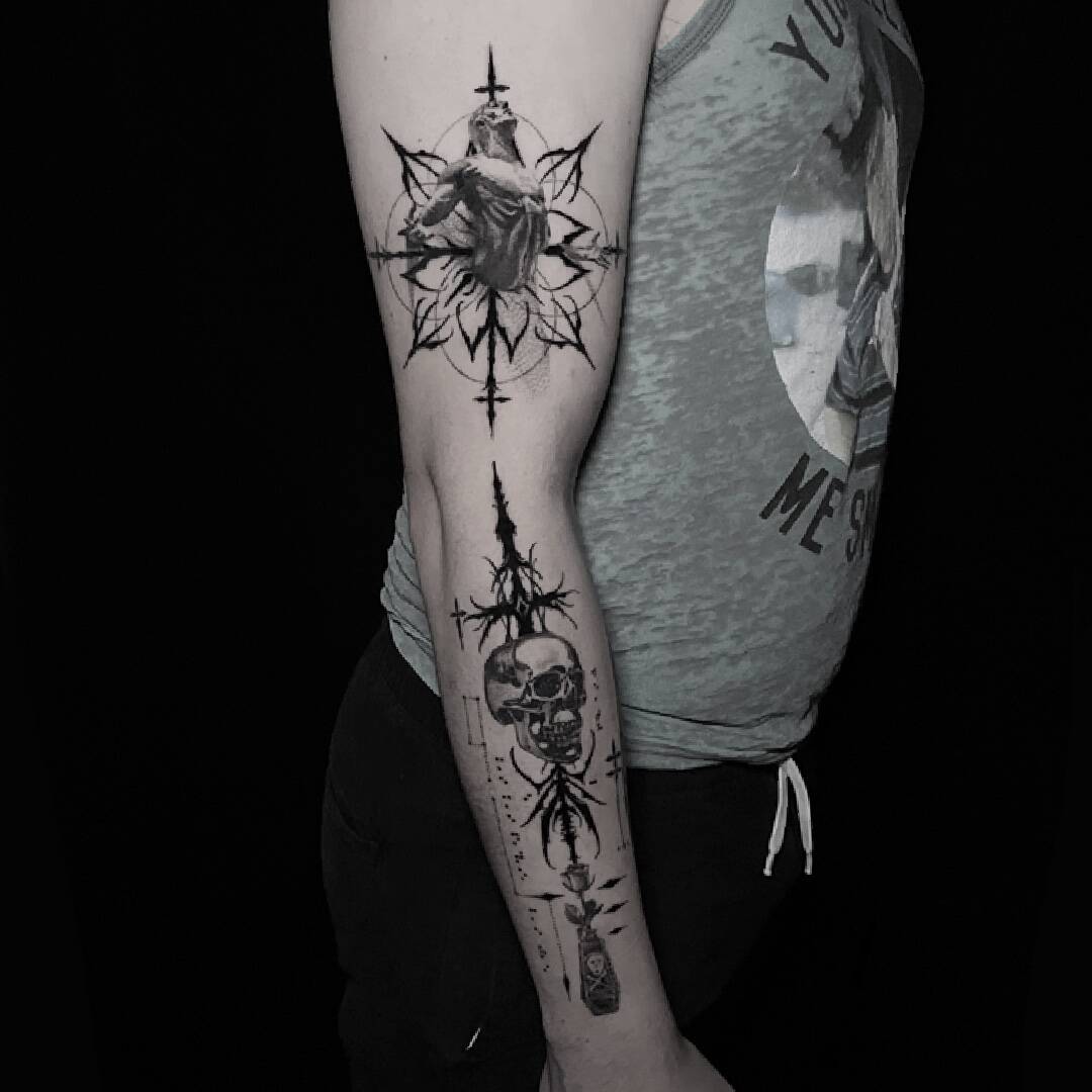 Full arm of high contrast ornamental blackwork tattoos spaced along the forearm and bicep.