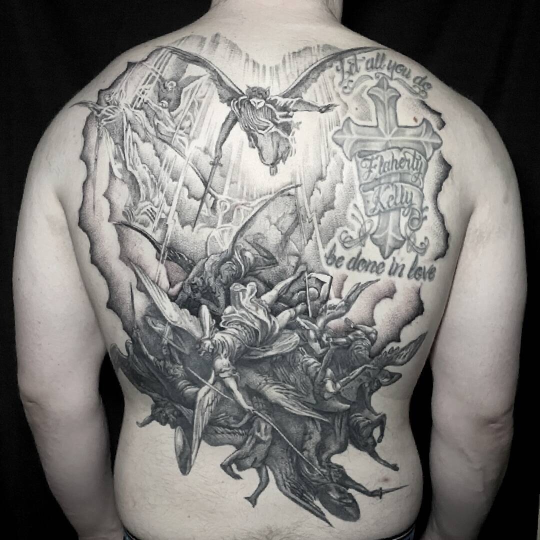 Large black and grey back tattoo of a dense figurative scene with banners and lettering.