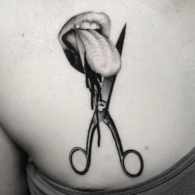 Surreal black and grey tattoo of scissors beneath open lips, on the hip.