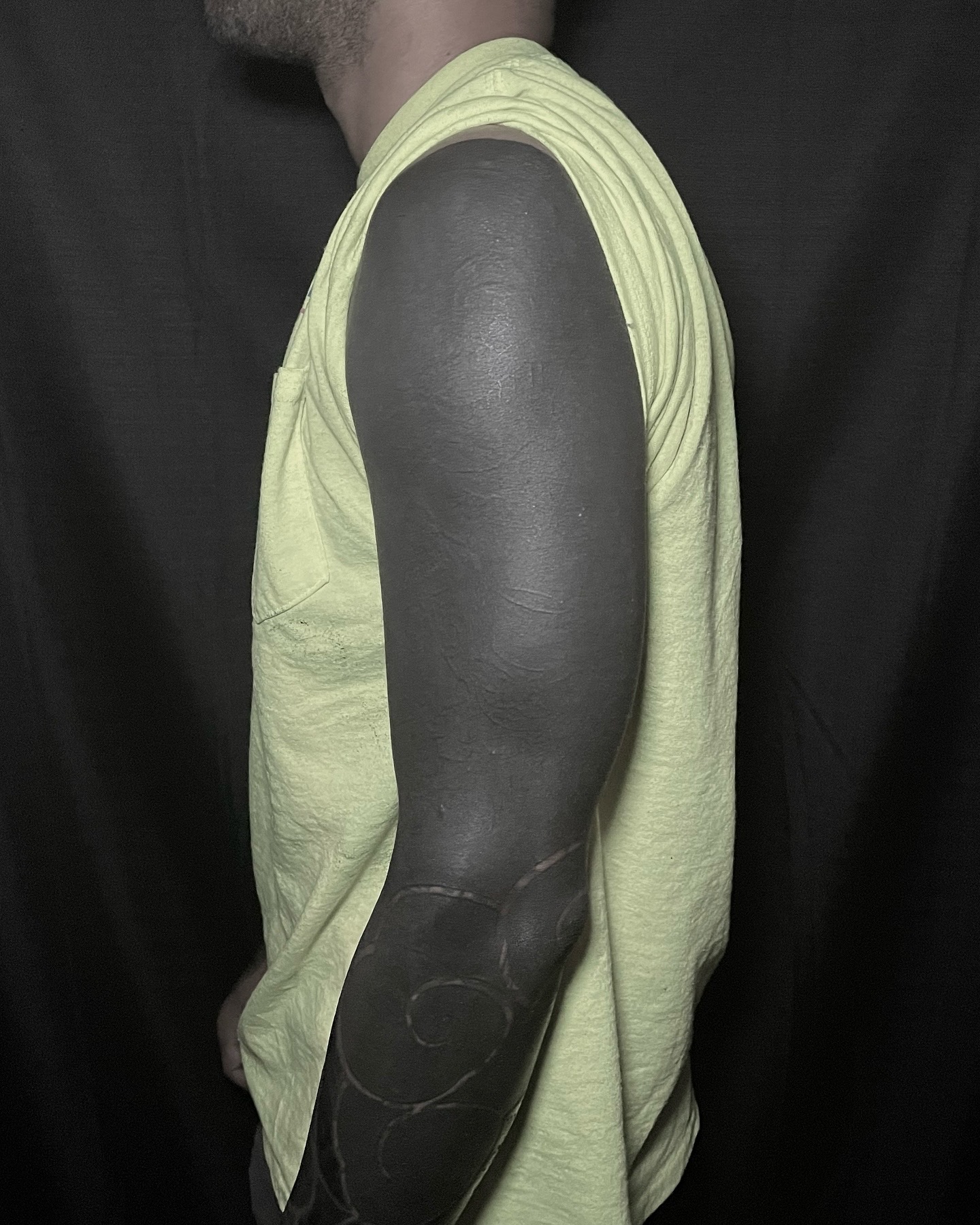 An arm tattooed entirely in solid black.