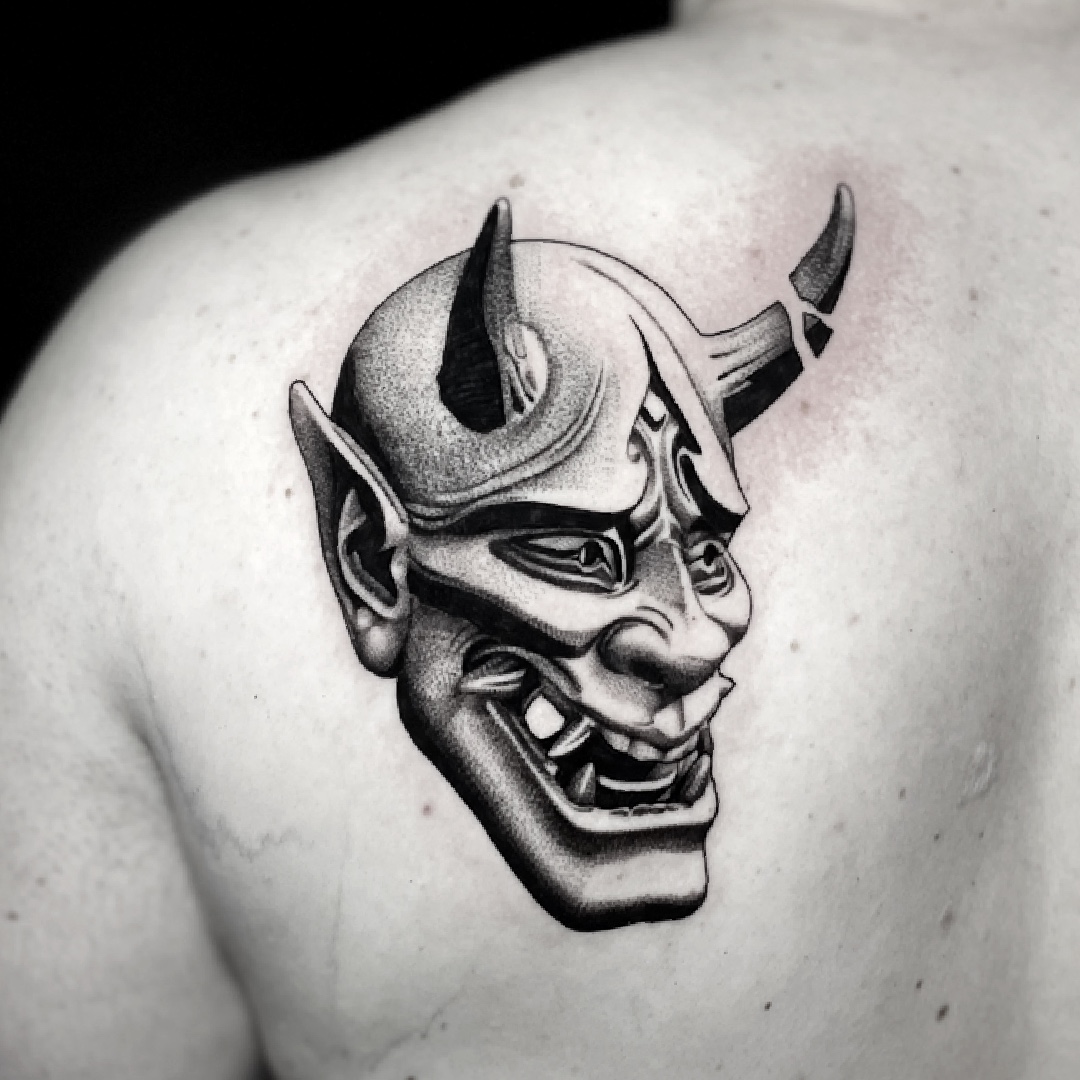 Black and grey hannya mask tattoo on the shoulder.